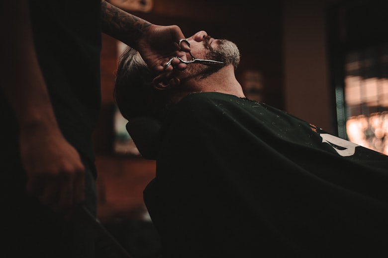 Barber shaping and trimming a beard with scissors
