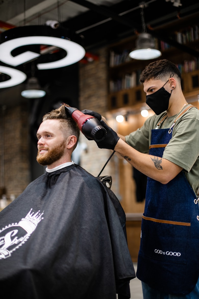 Barber styling a client after a full haircut and beard package